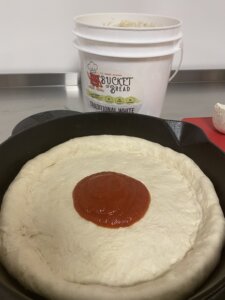 Add your pizza sauce for the Bucket of Bread cast iron pan for pizza